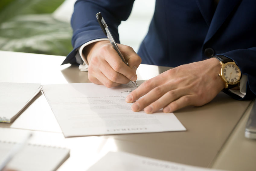 Male hand putting signature on contract, signing document, close